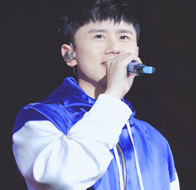 张杰穿黑白蓝三色连帽卫衣搭配黑色破洞牛仔裤