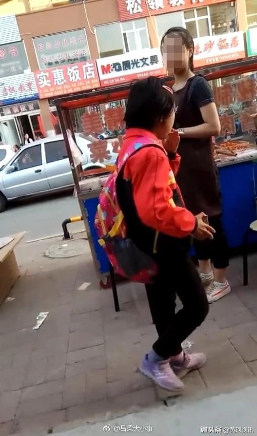 网友在山西晋城 街头碰见一名戴红领巾的小女孩在抽烟