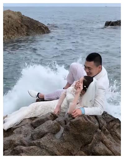 这对小夫妻在海边的礁石上拍了婚纱照.海浪太大,简直
