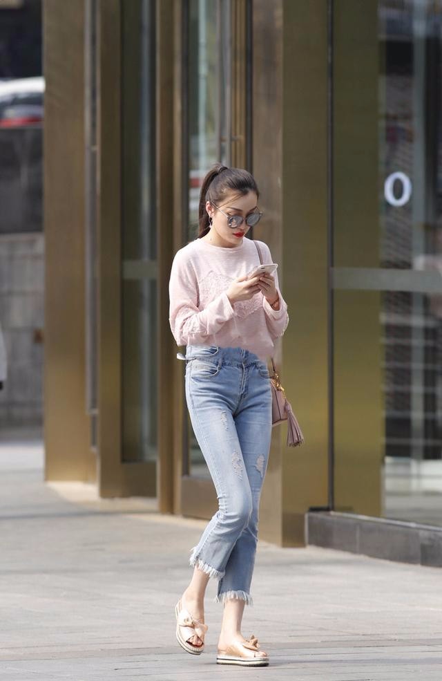 一头马尾辫十分的干练,上身是粉色的蕾丝上衣,下身是蓝色的九分牛仔裤