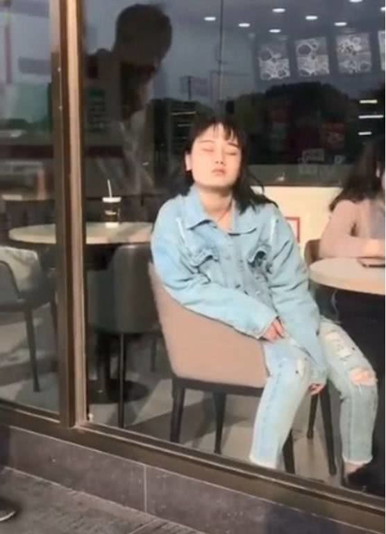 美女靠在奶茶店的玻璃上睡觉,路过小伙既然隔