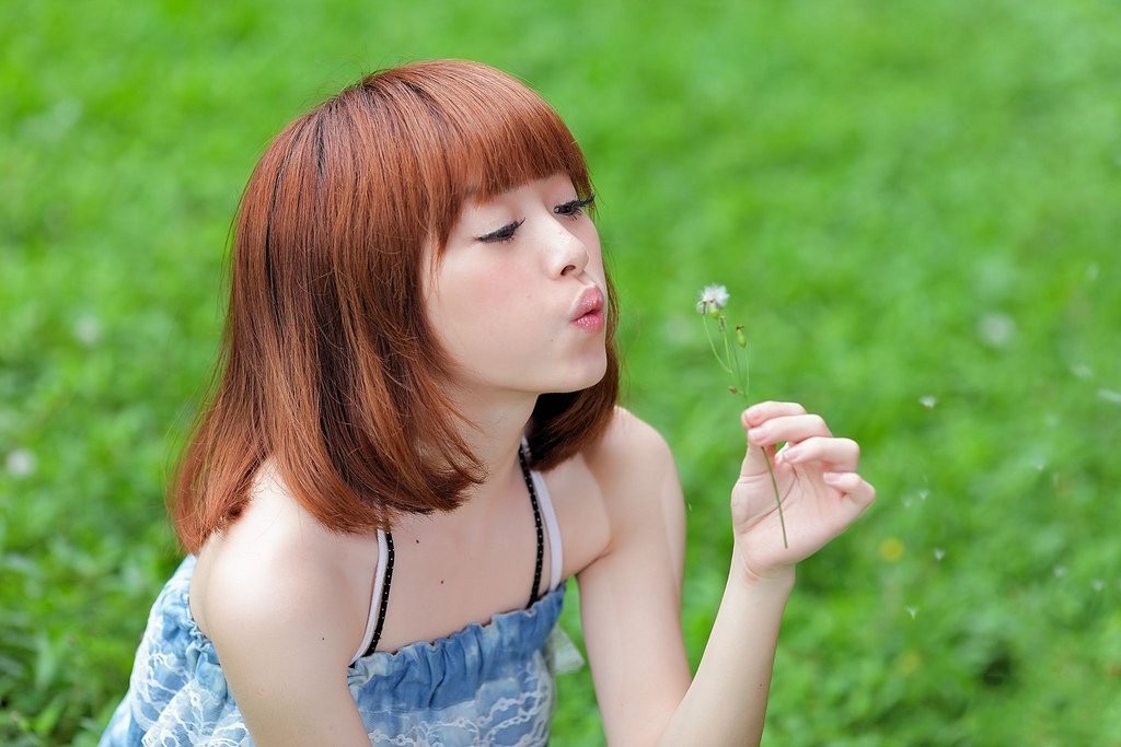 草地上的一个唯美清秀开心少女姑娘