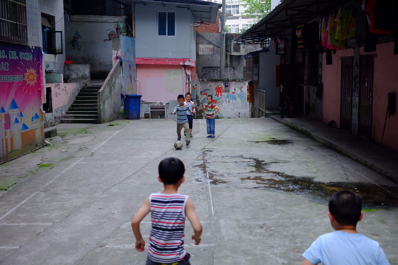 孩子们在这样的地方踢足球,场地真的太简陋了