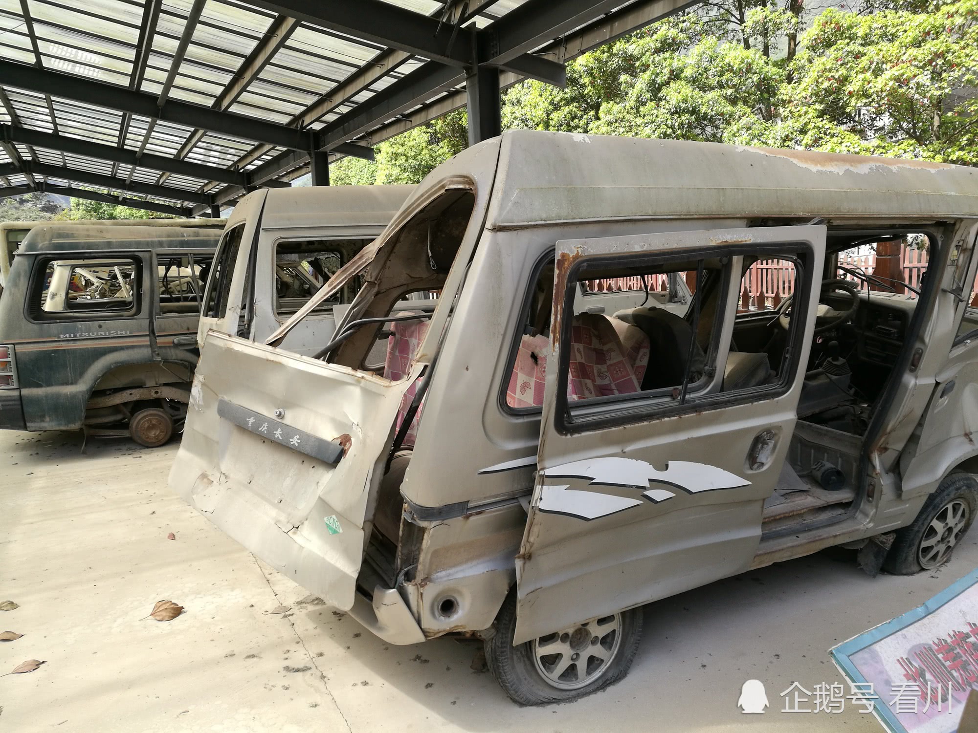 一辆被滚石挤压变形的面包车,地震巨大的摧毁力在一辆辆受损的汽车上
