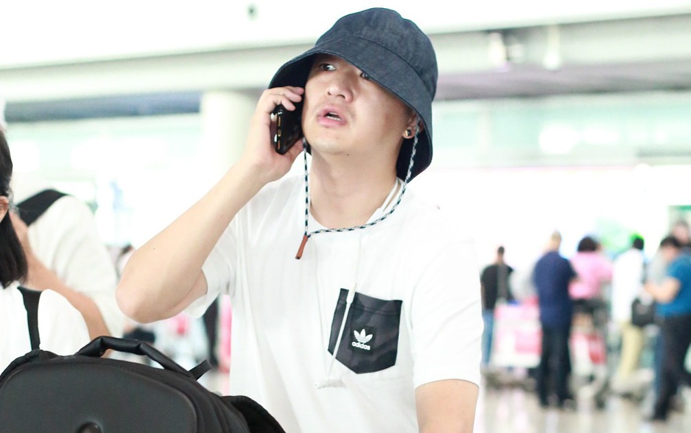 包贝尔戴耷拉帽子挡脸可爱现身机场耳上添