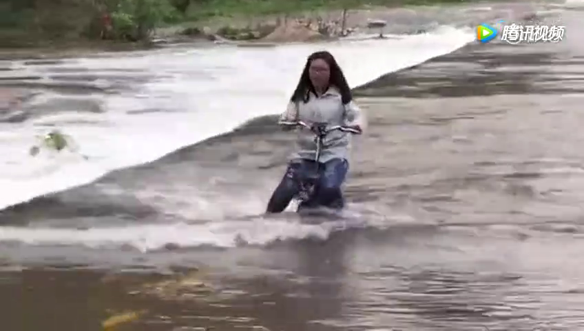 女子骑电动车横穿湍急河流，自己还捂嘴乐！