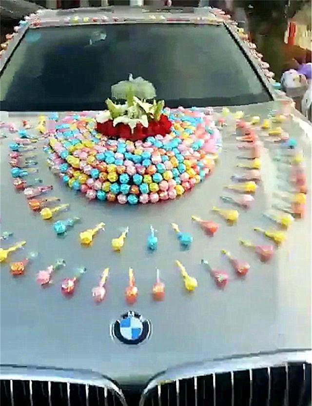 贵州一辆宝马7系婚车，车身粘999颗棒棒糖，象征“天长地久”