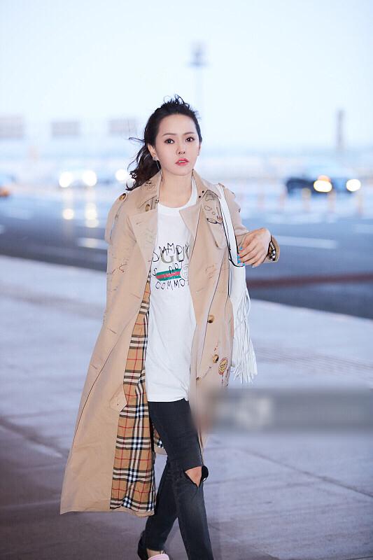 49岁伊能静最新机场街拍秀冻龄美颜,穿涂鸦风衣个性