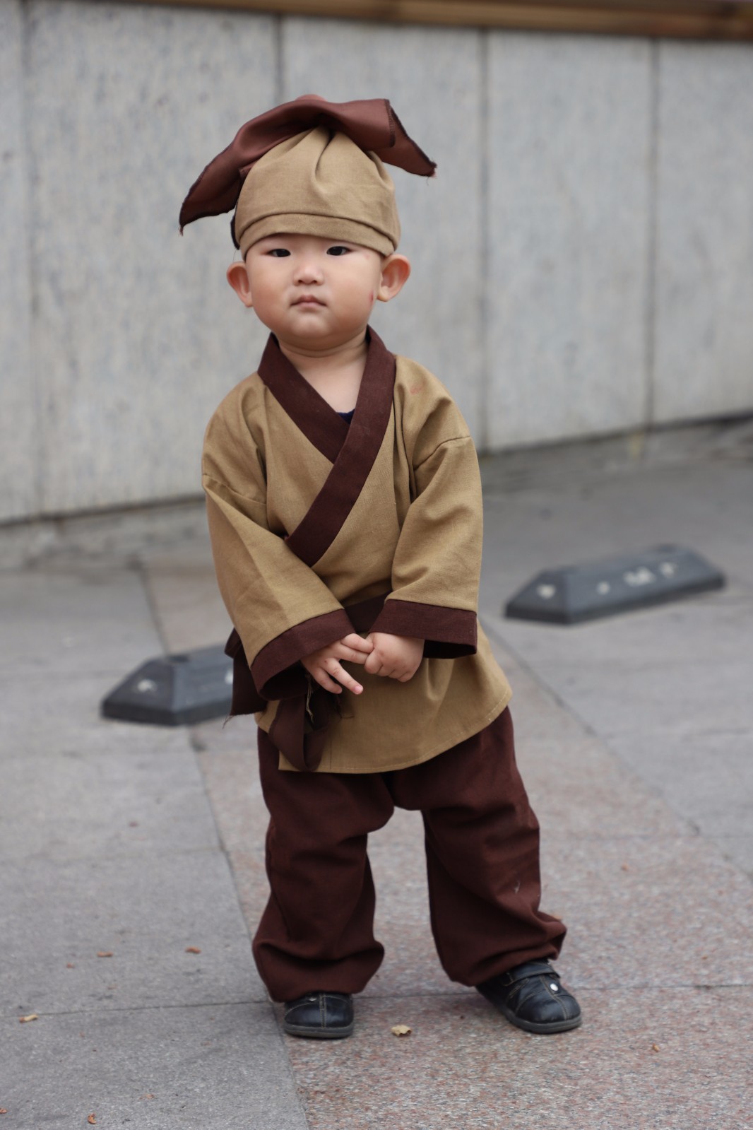 一岁萌娃穿店小二服装在钟楼玩耍 游客:来个