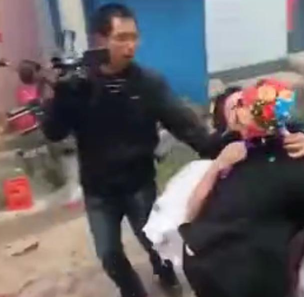 小伙子准备把新娘抱去新房中,可能是由于太激动,不小心摔倒在地,毕竟