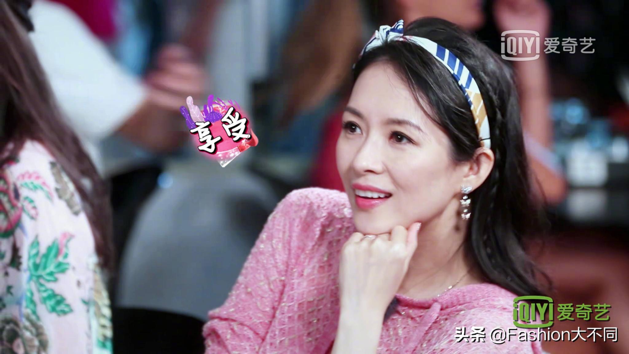 章子怡身穿粉色毛衫搭配彩条发带和耳饰,粉嫩青春宛如少女逆生长