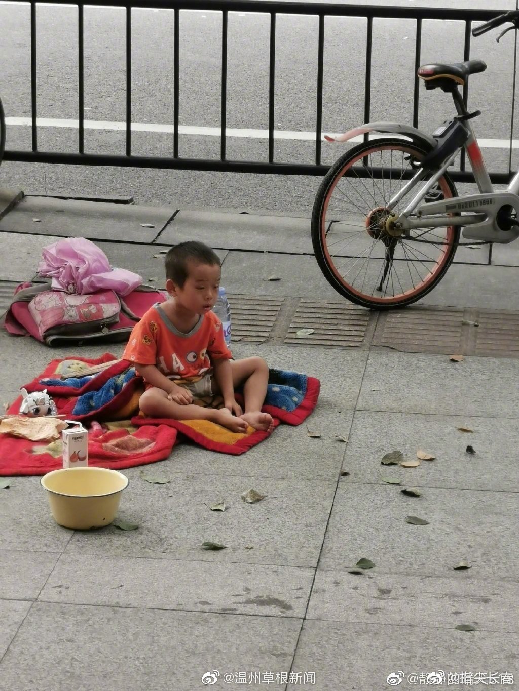 这么热天,小男孩一个人在开太百货对面的麦当劳后面口乞讨 ,一直打
