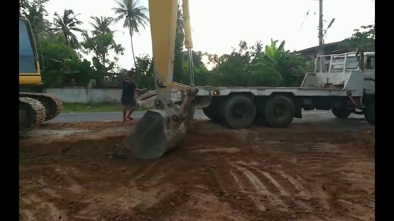 小松挖掘机上卡车，卡车前轮都翘起来了