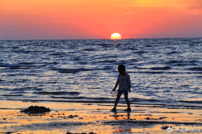 一个人走在能看到大海落日的海边