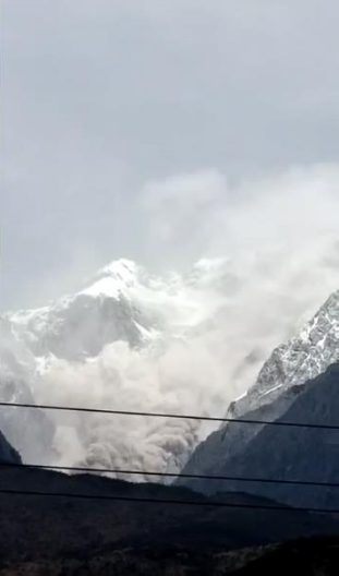 玉龙雪山山体岩石崩塌,局部区域伴随产生尘雾。云南网 图