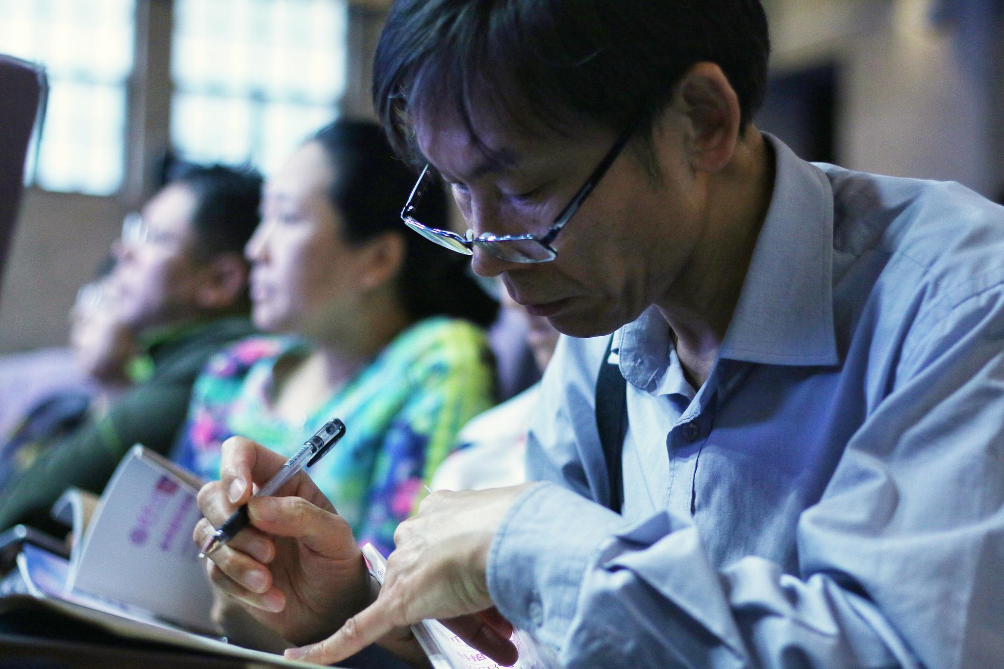 一位家长在清华大学大礼堂记录招生信息。摄影/新京报记者 陈婉婷