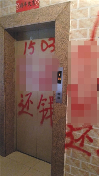 因为还不上钱,张洪家的楼道里被人喷上了红色油漆。