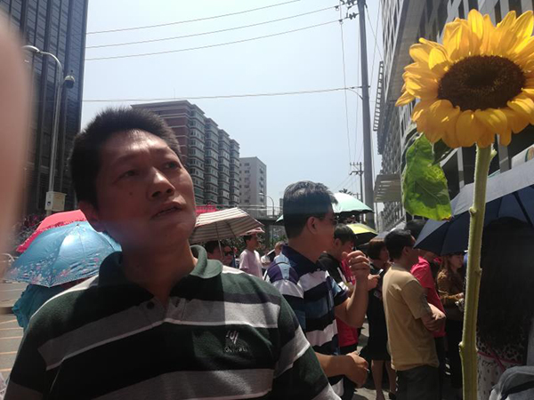 北京市八一学校考点外一家长拿着向日葵等孩子出来。五福彩票app下载澎湃新闻记者 廖瑾 图
