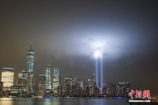   資料圖：當地時間2018年9月11日，美國“911事件”17週年，紐約世貿中心附近兩根象徵着世貿中心雙子塔的藍色光柱直衝雲霄，一直持續到黎明。中新社記者 廖攀 攝