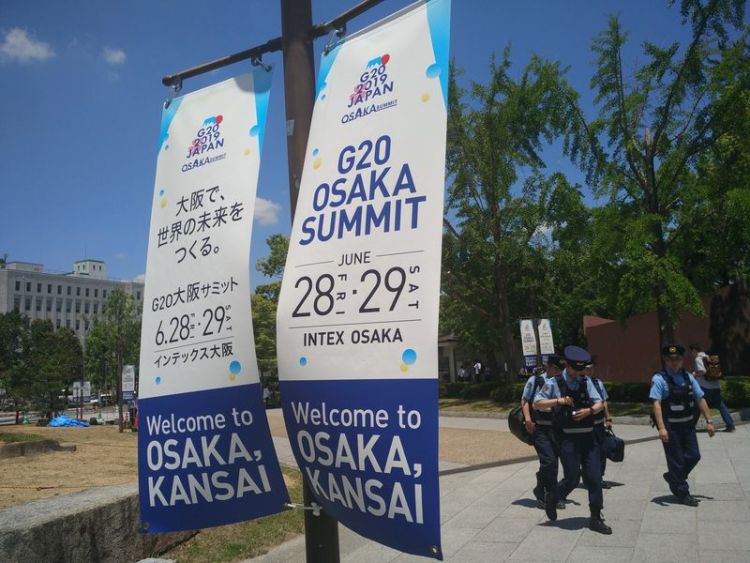在著名景点大阪城附近,几名警察从标有“在大阪创造世界未来”字样的条幅旁走过。新华社记者庞兴雷摄