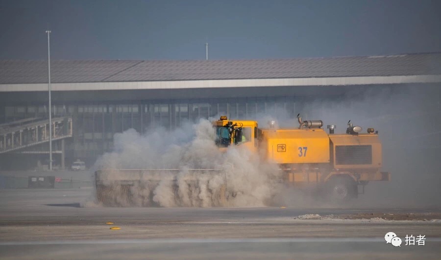 　△ 2019年1月21日，机场跑道飞行校验前，工作人员正在用大型设备清理跑道。摄影 / 新京报记者陶冉