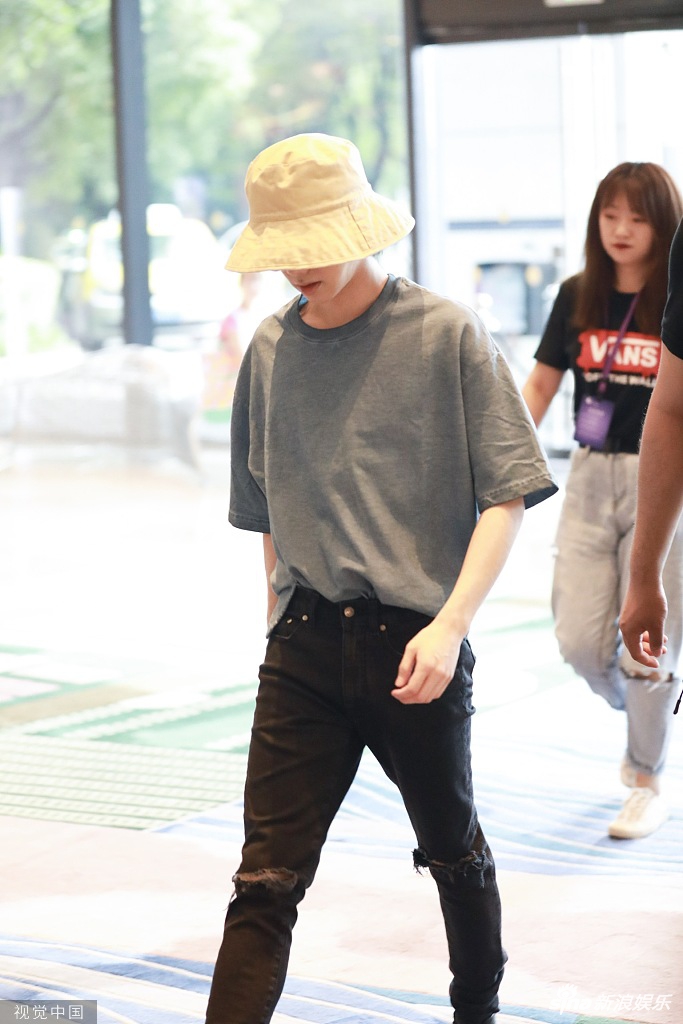 华晨宇破洞牛仔裤搭配小黄帽变夏日酷盖低头快步走