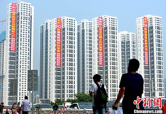 资料图:市民从正在销售的楼盘旁经过。中新社记者 张斌 摄