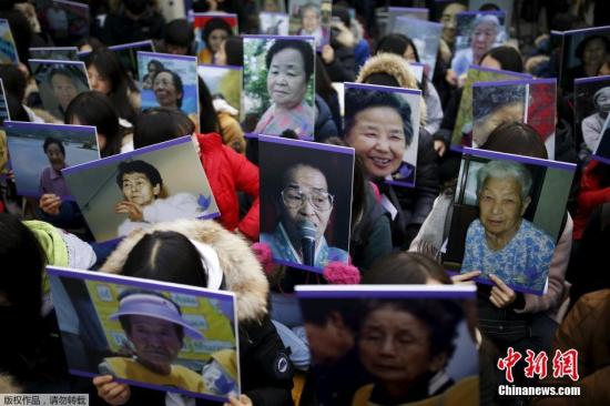 资料图：韩国首尔民众高举慰安妇的照片，在日本使馆前集会抗议。