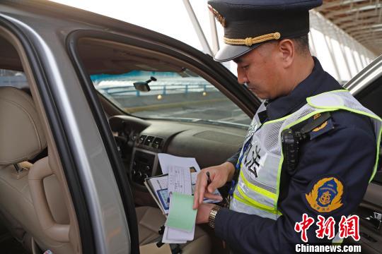 资料图:民警核查网约车运营资质。殷立勤 摄