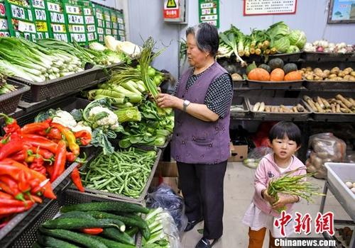 资料图:市民在居住地附近的社区蔬菜副食品直销点,购买新鲜蔬菜等食材。中新社记者 刘新 摄