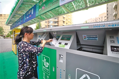 西城区德胜街道新风街一号院推出“人脸识别”垃圾桶,居民将垃圾投入厨余垃圾投放口。