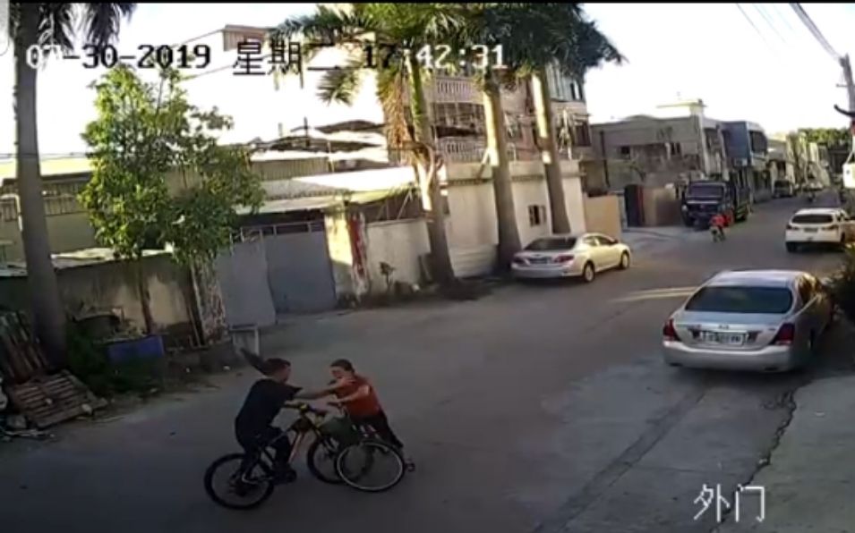 红衣女子持伞向对方挥打过去后,男子下车反击。视频截图