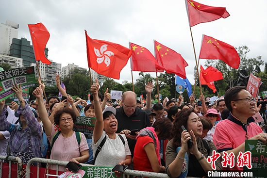 8月3日,团体“香港政研会”下午3时在维多利亚公园草地举行“希望明天”反暴力音乐会,表达对警队的支持。图为现场聚集大批民众,高呼口号,支持香港警察,支持特区政府。随处可见中华人民共和国国旗和香港特别行政区区旗迎风飘扬。 中新社记者 谢光磊 摄