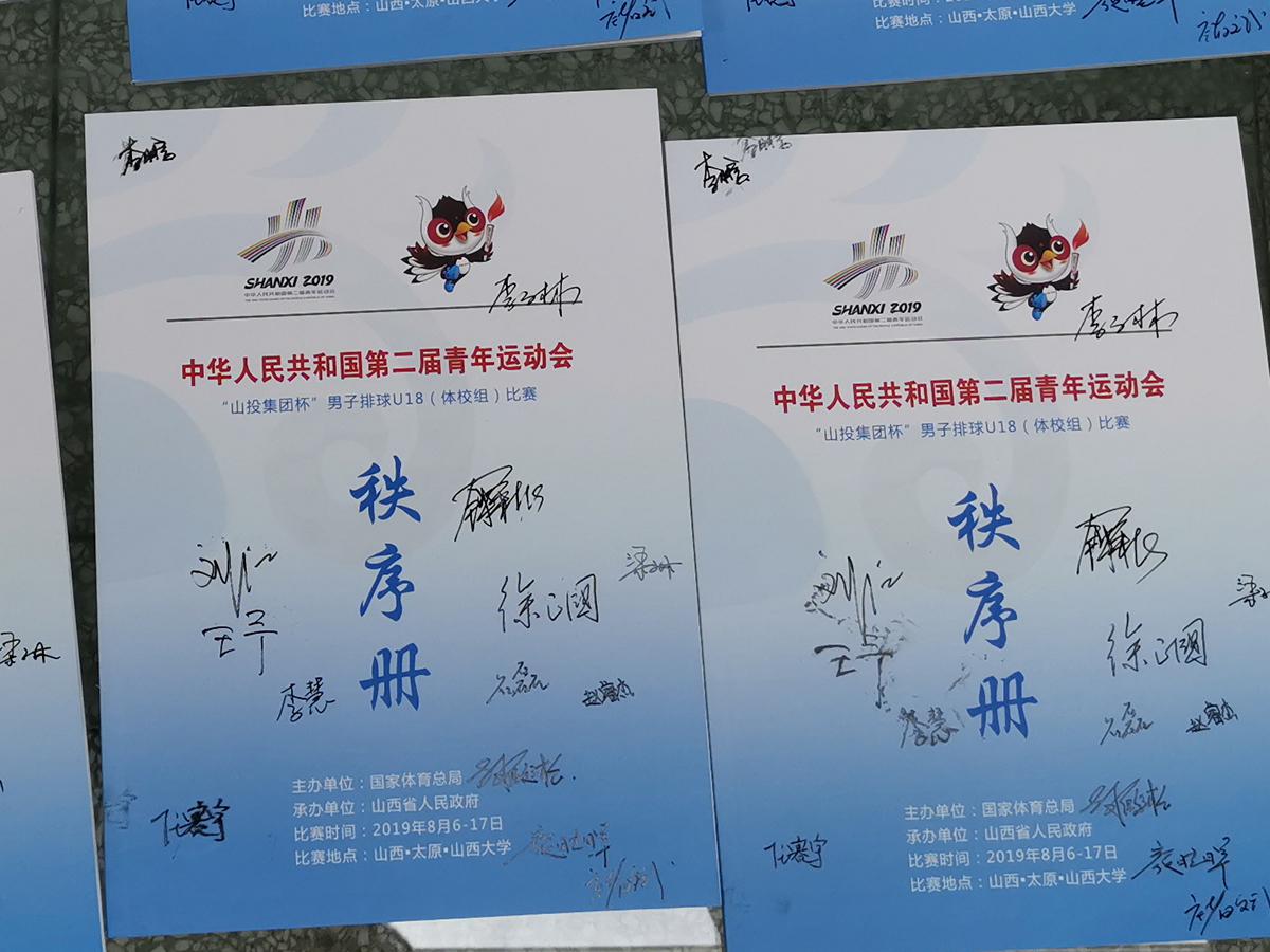 图为签名纪念秩序册和签名排球,山西大学赛区将赠送给山西省体育博物馆收藏