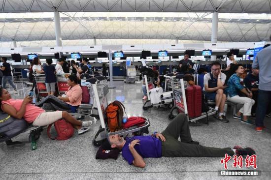 资料图:8月13日下午,大批示威者以机场手推车等堵塞香港国际机场1号客运大楼旅客登机行段及保安闸门。中新社记者 麦尚旻 摄