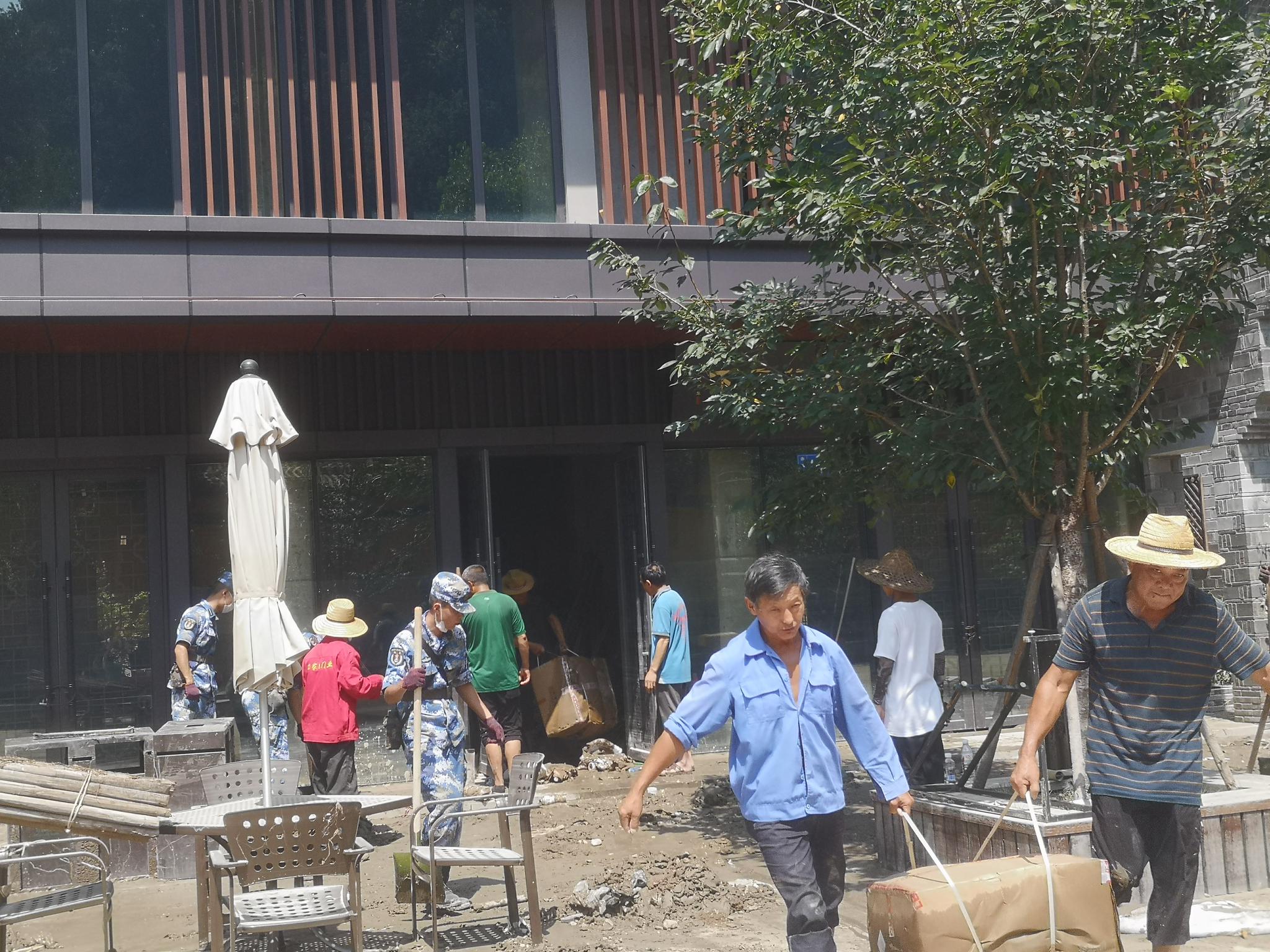 8月12日中午，有人在清理洪水过后留下的淤泥。 新京报记者 李桂 摄