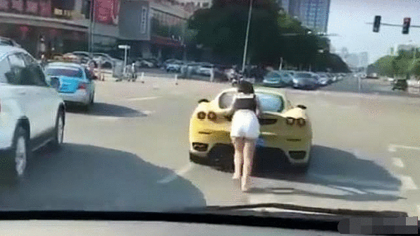 一个美女推车, 男子坐在车内, 网友: 恐怕是法拉利给的力量