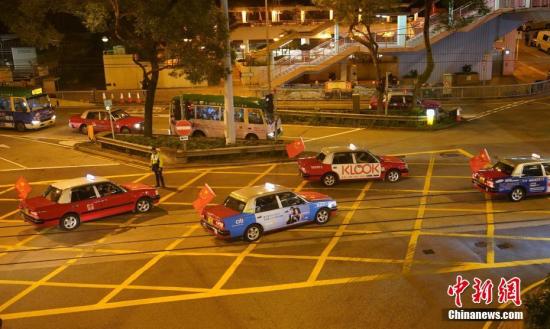  资料图：8月23日晚，“守护香港大联盟”联同香港的士司机从业员总会发起“守护香港·风雨同舟”大行动，在港岛筲箕湾中心，有超过140多辆出租车车身贴着海报，车尾悬挂五星红旗依次有序驶向主干道，呼吁社会反对暴力。中新社记者 张炜 摄