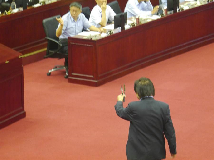 台北市议员王世坚今（11日）在台北市议会上，拿出刀叉送给柯文哲，叫柯别再用刀叉吃人肉。（图片来源：台湾“中时电子报”）