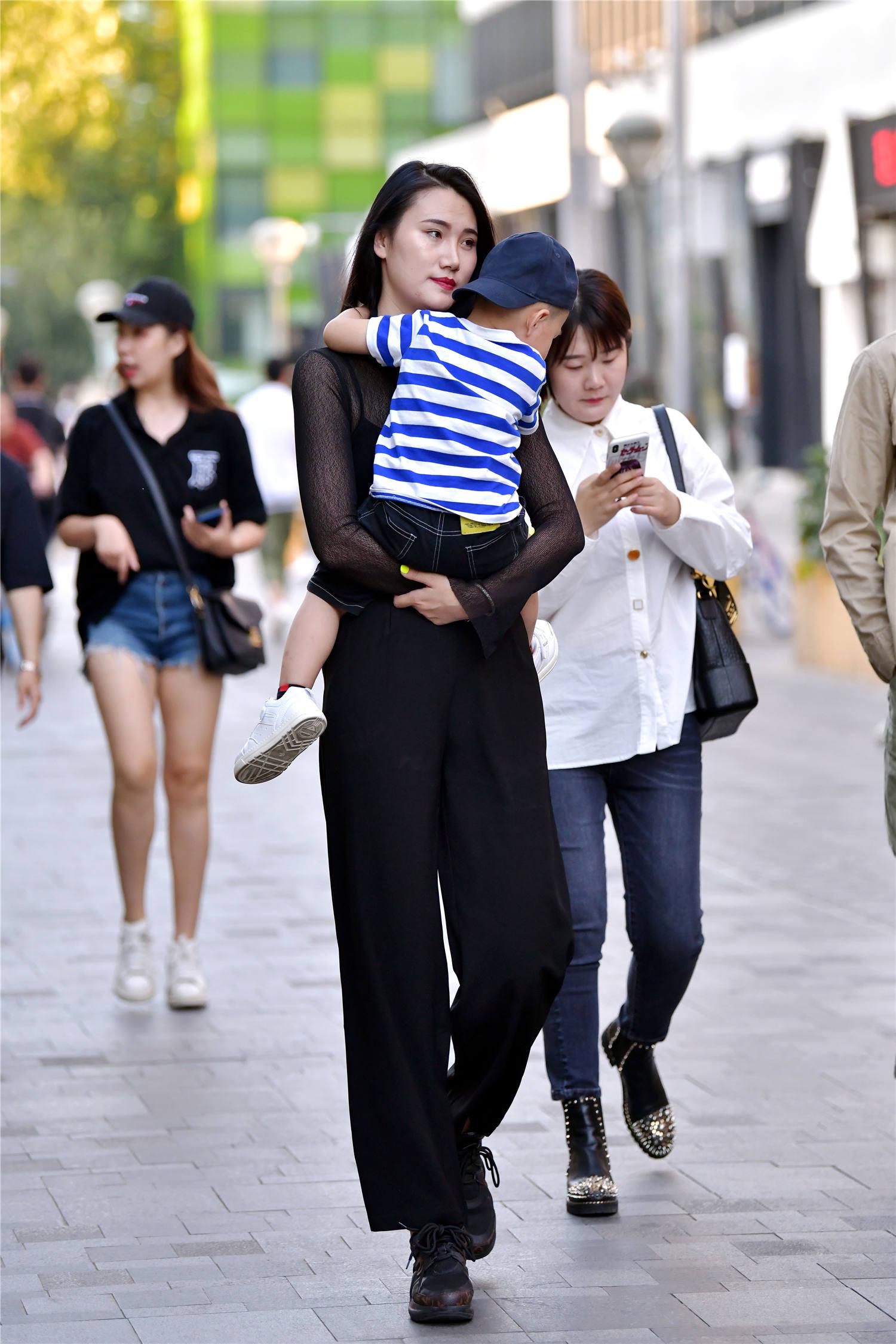 平时拧瓶盖都费劲的时尚辣妈抱起自己的孩子却毫不含糊