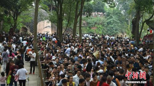 10月3日,四川乐山,游客排队下栈道观大佛。当日,乐山大佛景区迎来国庆长假客流高峰,景区内游人如织。中新社记者 刘忠俊 摄