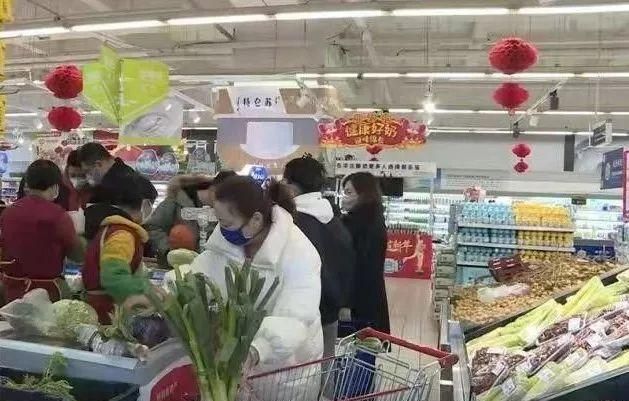 在振华商厦,家家悦超市入口处,工作人员手持测温仪对进出超市的市民逐
