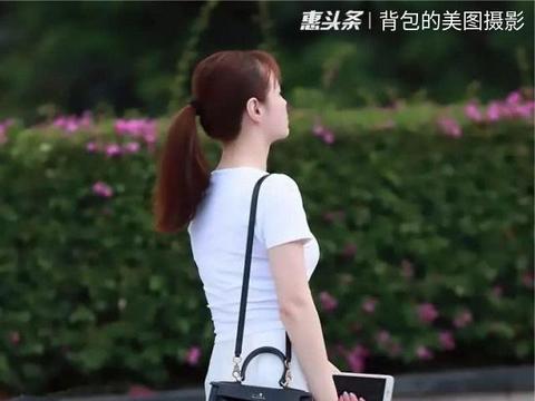 路人街拍，美女穿一件黑色的无袖中高领上衣，满满的性感元素