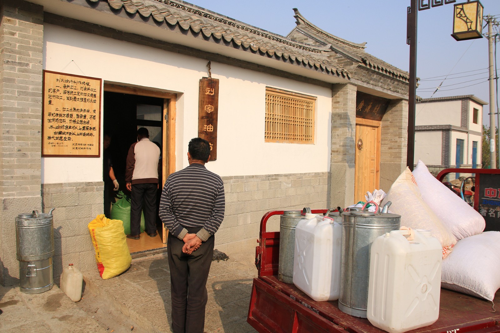 农村里的老油坊现榨油，村民提数只大桶买油