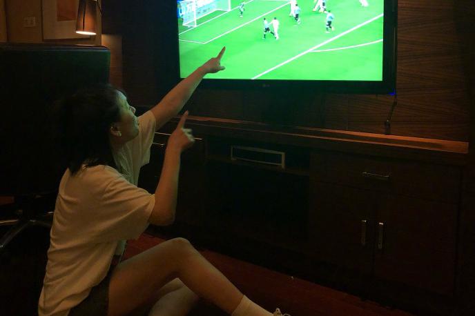 马思纯两只手指着电视机,看乌拉圭对阵俄罗斯