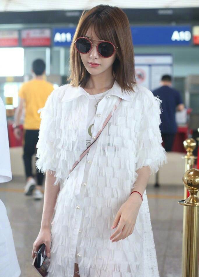 毛晓彤齐肩短发搭配白色羽毛长裙现身机场 仙
