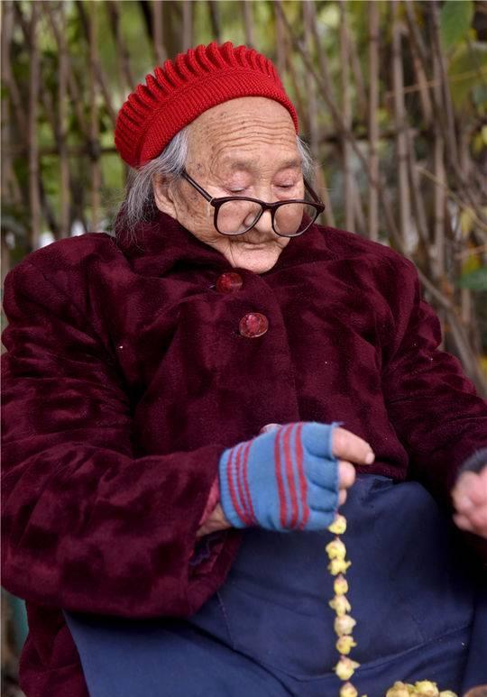 而有个老婆婆,80多岁,坐在街角,带着老花眼镜,一针一线,安静地穿着