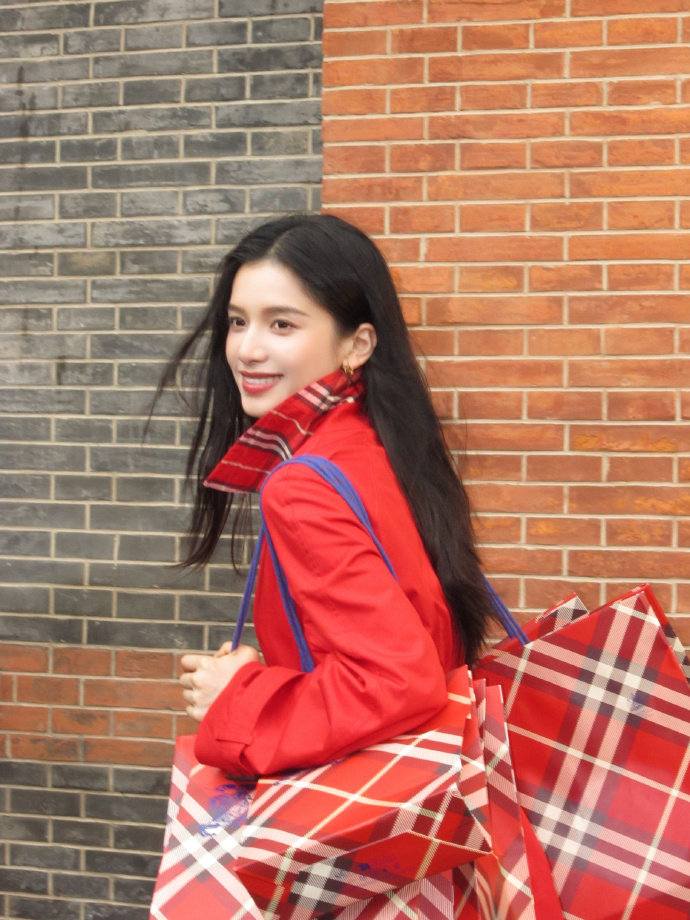 张婧仪穿Burberry红风衣亮相街头，马年徽标设计年味十足