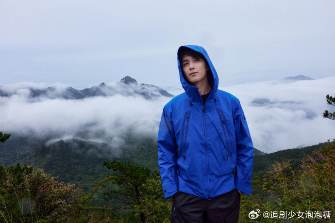 吴磊蓝色冲锋衣棒球帽造型亮相，展现自然户外活力