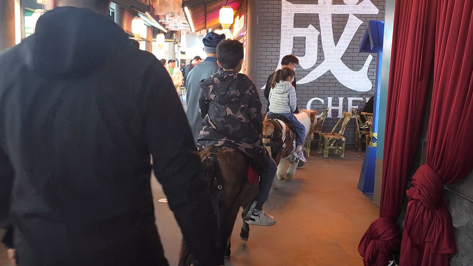 这个网红打卡地有点意思，游客吃着美食玩穿越，小朋友骑着马逛街